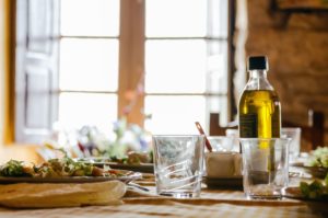 food, glasses, and olive oil on a table