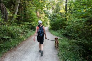 woman walking dog on a trail